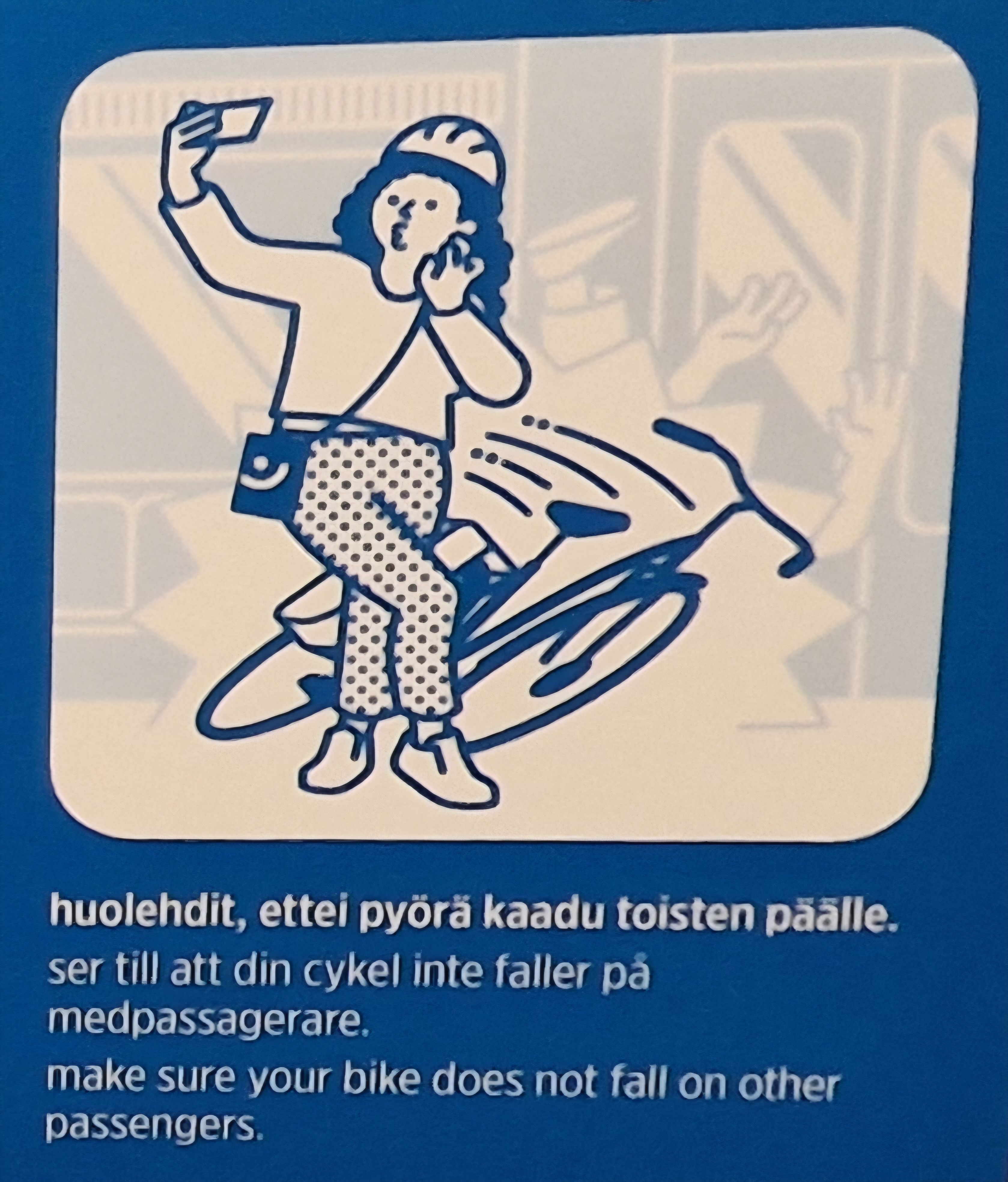 Pyöräilijä ottaa itsestään selfietä samaan aikaan, kun pyörä kaatuu takana olevan matkustajan päälle. Matkustaja on erityisen haalea vaaleaa taustaa vasten. Tekstinä lukee 'huolehdit, että pyörä ei kaadu toisten päälle'.